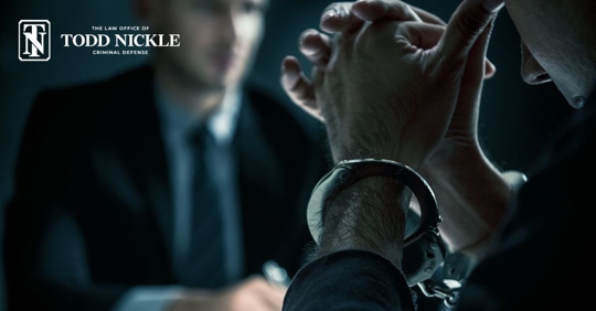 handcuffed man talking to a lawyer